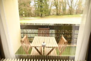 a table and two chairs on a porch with a window at Maison-Home-ZuHause in La Calamine
