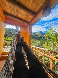 a hammock hanging from a porch with a view at Cabaña Bachué in Sutatausa