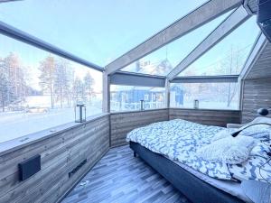 a bedroom with a bed in a room with windows at Panorama Iglu Hankasalmi Resort in Hankasalmi