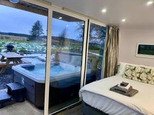 a bedroom with a tub with a view of a patio at The Lux Pod in Ballynameen