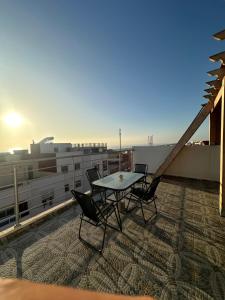 a table and chairs on the roof of a building at Wavera Surf Camp in Imsouane