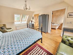 a bedroom with a bed and a bath room at The Byre - by Where Stags Roar in Newtonmore