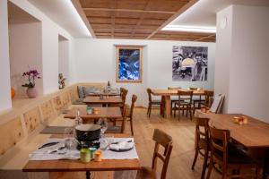 a dining room with wooden tables and chairs at Camere Osteria Bäkar, Val Bedretto in Bedretto