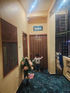 a woman standing in front of a door with flowers at Pushpkali Seva Sadan in Mathura
