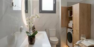 a bathroom with a toilet and a vase with flowers on a counter at 360 Skyline Suite, Argostoli in Argostoli +10 photos