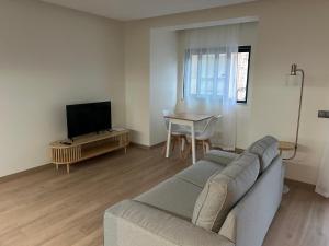 a living room with a couch and a tv and a table at Casa aOrta Apartments in Faro