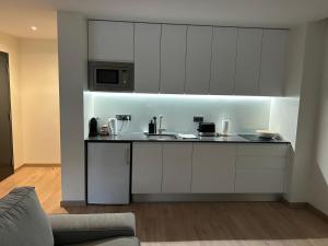 a kitchen with white cabinets and a counter at Casa aOrta Apartments in Faro
