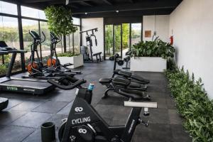 a gym with several treadmills and elliptical machines at Garden views in Juriquilla