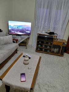 a living room with a cell phone on a coffee table at Valbona in Korçë