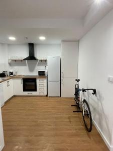 a bike parked in a kitchen with a refrigerator at Apartaments Montseny in Girona +19 photos