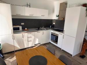 a kitchen with white cabinets and a sink at Comfort Apartment for 6 & Loggia & Free Parking in Žilina