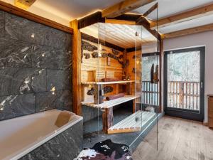 a bathroom with a tub and a glass wall at Bergromantik Ferienwohnung Harmonie mit Sauna, Whirlpool und Bergblick in Marktschellenberg