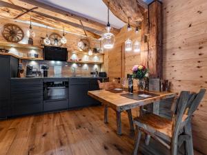 a kitchen with wooden walls and a wooden table and chairs at Bergromantik Ferienwohnung Harmonie mit Sauna, Whirlpool und Bergblick in Marktschellenberg +30 photos