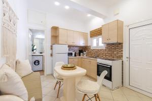 a kitchen with white appliances and a table and chairs at Golden Secret Beach House in Perissa