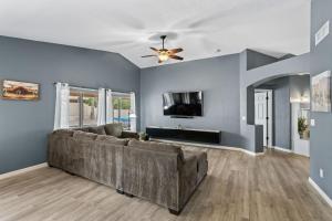 a living room with a couch and a ceiling fan at Private Pool & Fire Pit: Tucson Home Near Hiking! in Tortolita