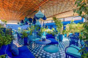 a patio with blue chairs and tables and plants at Riad & Spa Stella Cadente Marrakech in Marrakesh