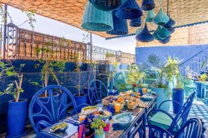 a patio with blue tables and chairs and potted plants at Riad & Spa Stella Cadente Marrakech in Marrakesh