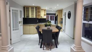 a kitchen with a table and black chairs in a room at Frankie's Nest in Cape Town