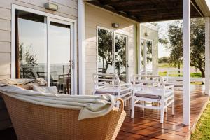 a porch with white chairs and tables and windows at Mobile Homes Sunset Beach in Umag +26 photos