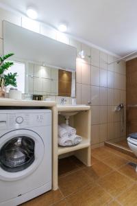 a bathroom with a washing machine and a sink at Golden Secret Beach House in Perissa