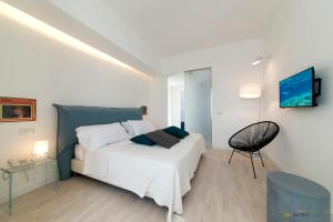 1 dormitorio con 1 cama blanca y 1 silla en B&B San Pietro, en Isquia