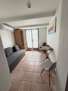 a living room with a couch and a table at Hôtel Quai d'Azur in Le Grau-du-Roi