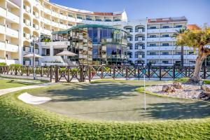 a golf course in front of a large building at Ondamar Hotel Apartamentos in Albufeira