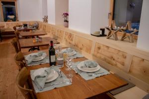 a dining room with a table with a bottle of wine at Camere Osteria Bäkar, Val Bedretto in Bedretto +28 photos