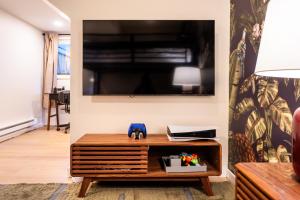 a living room with a tv and a wooden table at The Icelander at Mammoth Point in Mammoth Lakes