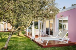 a deck with chairs and a tree on a house at Mobile Homes Sunset Beach in Umag