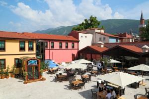 an outdoor patio with tables and umbrellas in a town at Bursa İpekyolu Hotel in Bursa