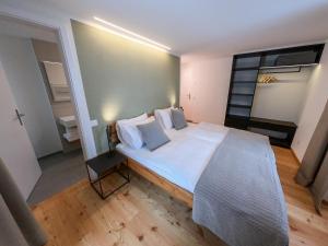 a bedroom with a large bed with white sheets and pillows at Camere Osteria Bäkar, Val Bedretto in Bedretto