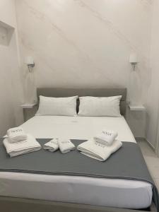 a white bed with two folded towels on it at NOGA rooms in Porto Cesareo