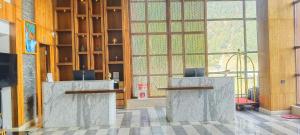 a lobby with two reception desks and a large window at Four Points by Sheraton Sonmarg Resort in Sonāmarg