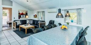 a dining room with a table and a living room at VE400-Vejers-Strand-Engesovej-52 in Vejers Strand