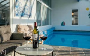 a bottle of wine and two glasses on a table at VE400-Vejers-Strand-Engesovej-52 in Vejers Strand