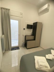 a bedroom with a bed and a window and a television at NOGA rooms in Porto Cesareo