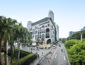 a large building on a city street with palm trees at Petchaburi31 Platinum Suite Home in Bangkok