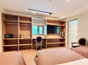a bedroom with two beds and a desk and a tv at Hm Montes Central in Cusco