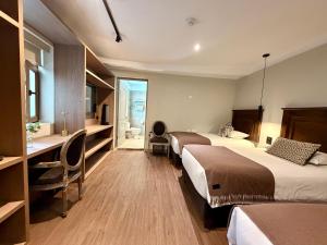a hotel room with two beds and a desk at Hm Montes Central in Cusco