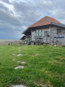 an old house in a field of green grass at Šebovina Jelova gora in Starčevići