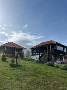 a couple of buildings in a field with grass at Šebovina Jelova gora in Starčevići