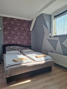 a bedroom with a bed with two towels on it at Siófok 7 Apartmanház in Siófok