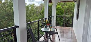 a balcony with a table and chairs and trees at Villas De Morne St Lucia in Grande Rivière