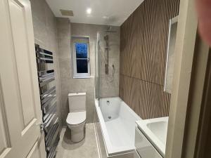 a bathroom with a toilet and a tub and a sink at Princes Risborough, Buckinghamshire, comfortable double room, quiet and central location in Buckinghamshire