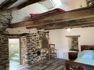 a bedroom with a bed and a stone wall at La grange de Jean et Claude in Barre-des-Cévennes
