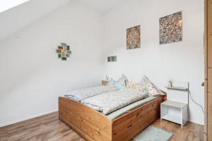 a bedroom with a wooden bed and paintings on the wall at Natururlaub Eifel-Mandala Feriewohnung in Kall +6 photos