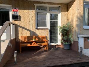 a wooden bench sitting on a porch next to a building at Lipno Pearl Terasa in Lipno nad Vltavou