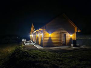 a small wooden house with lights on it at night at Dom na słodkim wzgórzu in Trzebinia