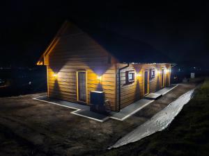 a small wooden cabin with lights on it at night at Dom na słodkim wzgórzu in Trzebinia +28 photos